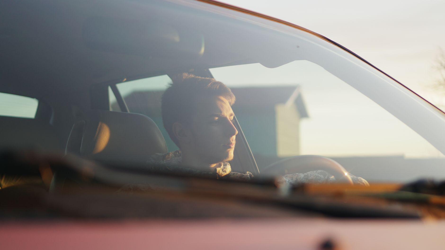 A person sitting in a car taking a slow, steadying breath before driving